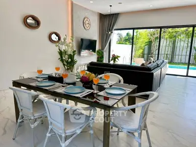 Modern open-plan living room with pool view, stylish dining area, and elegant decor