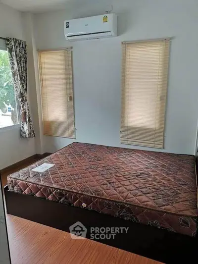 Cozy bedroom with air conditioning and natural light, perfect for relaxation and comfort.