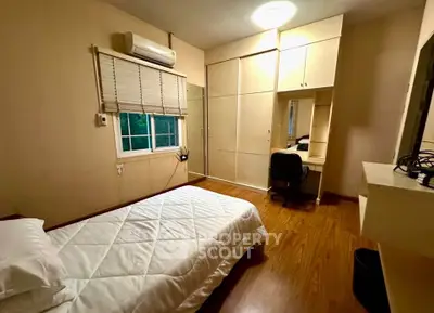 Cozy bedroom with wooden flooring and built-in wardrobe, perfect for restful nights.