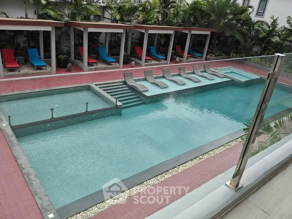 Luxurious outdoor pool area with stylish loungers and lush greenery, perfect for relaxation and leisure.
