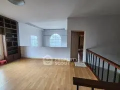 Spacious open living area with wooden flooring and large windows