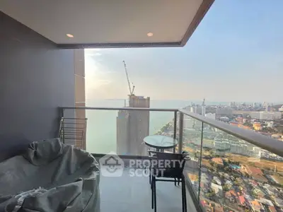 Stunning high-rise balcony with panoramic city and ocean views, perfect for relaxation and enjoying sunsets.