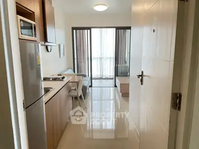 Modern open-plan living room with kitchen and balcony in a stylish apartment.