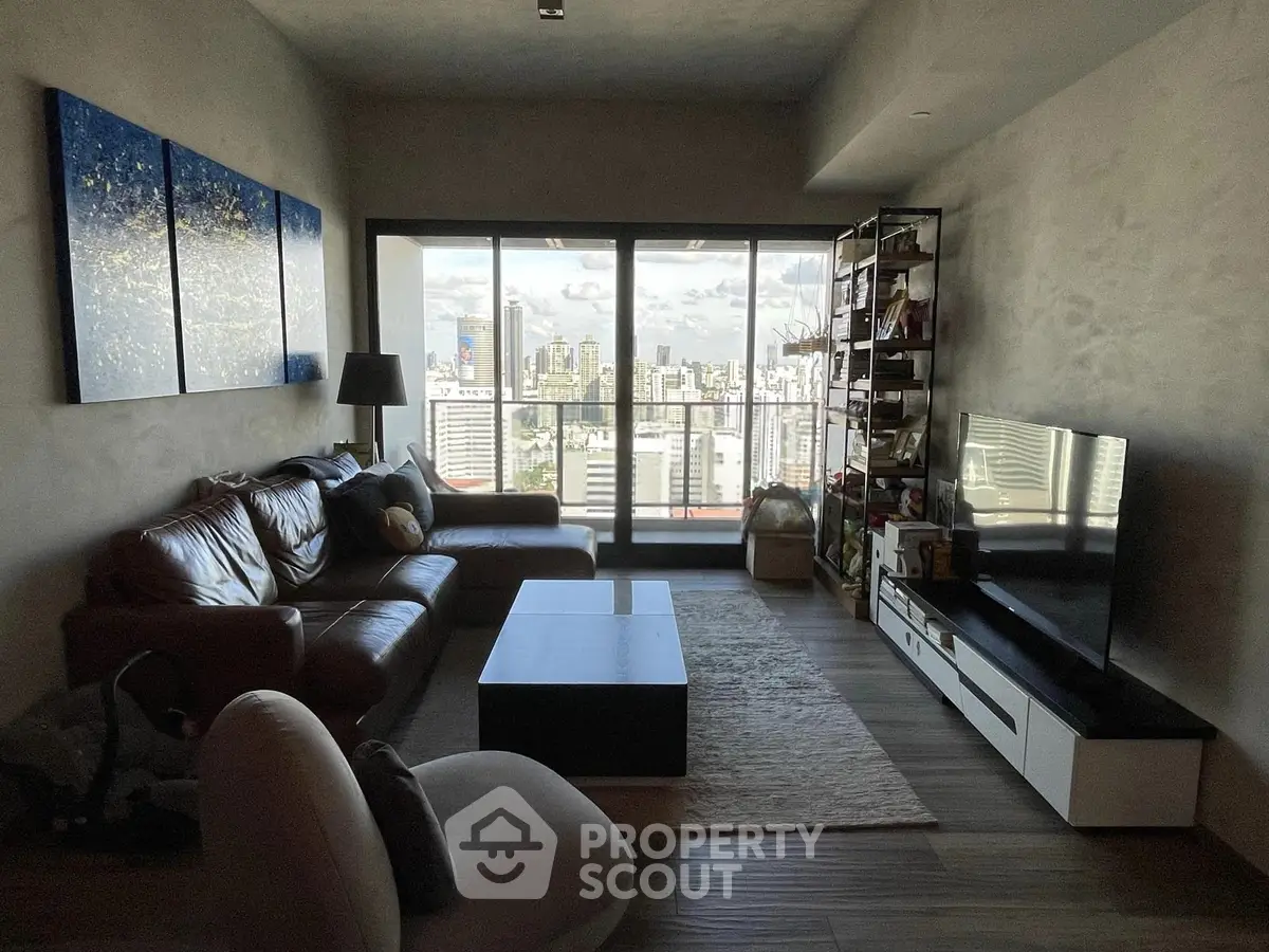 Modern living room with city view, leather sofa, and stylish decor in high-rise apartment.