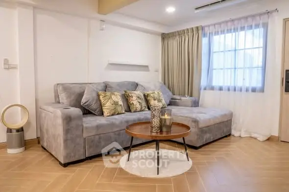 Stylish living room with modern gray sofa and elegant decor in a cozy apartment.