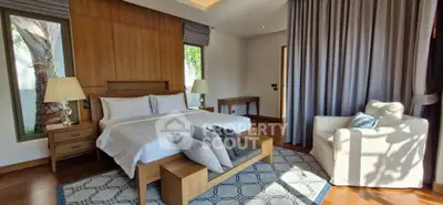 Luxurious bedroom with elegant decor and natural light, featuring a cozy armchair and stylish wooden furniture.