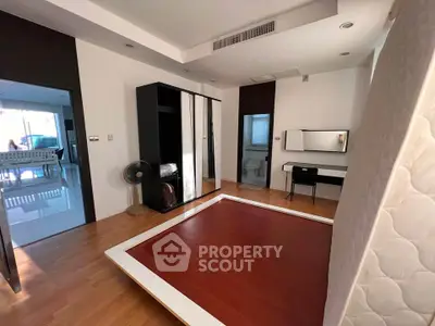 Spacious bedroom with modern design and ample natural light, featuring a sleek wardrobe and stylish vanity.