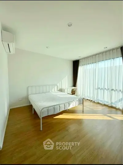 Bright and airy bedroom with large windows and minimalist decor