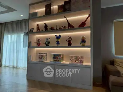 Stylish living room with illuminated display shelves and modern decor.