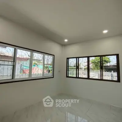 Bright and airy room with large windows and marble flooring, perfect for a modern living space.