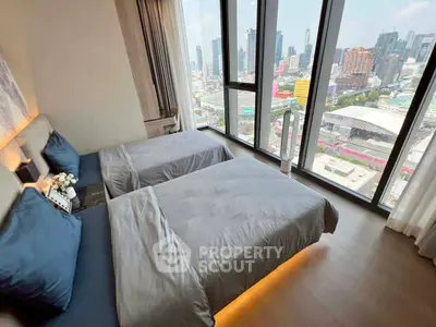 Luxurious bedroom with stunning city view and modern twin beds in high-rise apartment.