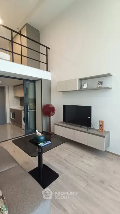 Modern loft apartment with sleek living room and mezzanine, featuring stylish furniture and open layout.