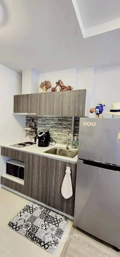 Modern kitchen with sleek cabinetry and stainless steel fridge in a stylish apartment.