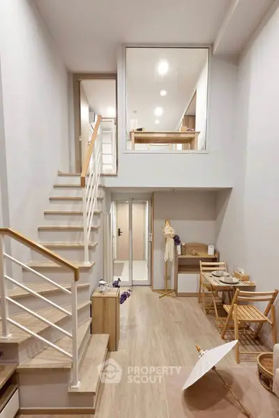 Modern duplex interior with stylish wooden staircase and cozy dining area