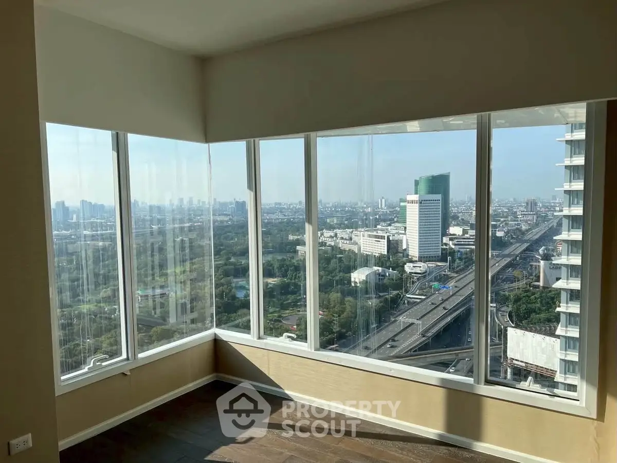 Stunning corner unit with panoramic city view from floor-to-ceiling windows, offering abundant natural light.