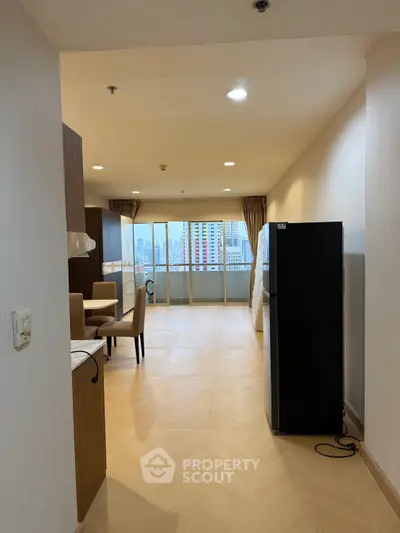 Spacious open-plan living area with dining set and city view balcony.