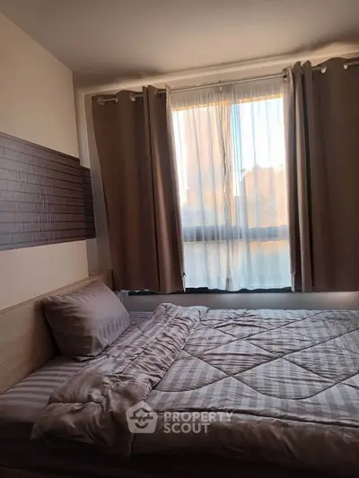 Cozy bedroom with natural light and modern decor, featuring a comfortable bed and stylish curtains.