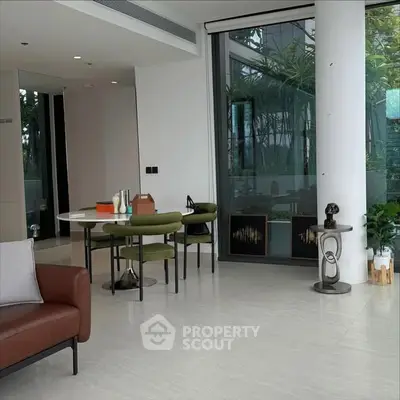 Modern living room with stylish furniture and large windows offering garden views.
