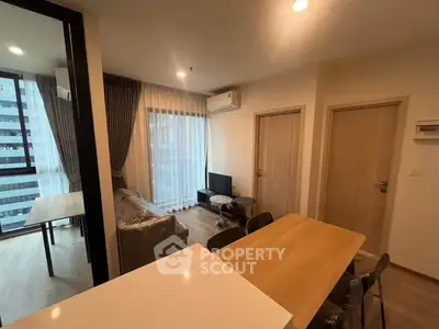 Modern living room with dining area and large windows in a stylish apartment.