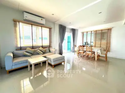 Spacious modern living room with dining area and large windows for natural light.