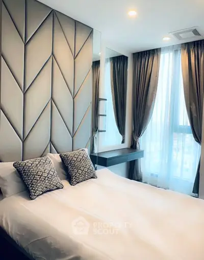 Luxurious bedroom with elegant decor and large windows offering natural light.
