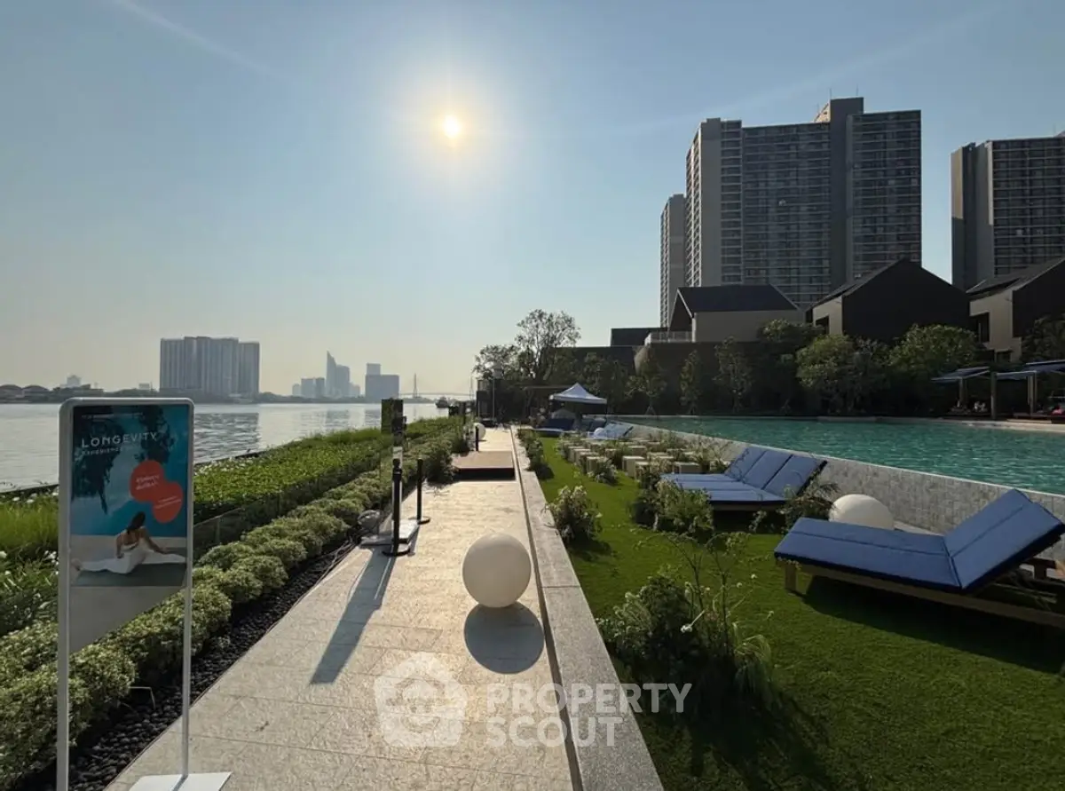 Luxurious riverside pool area with city skyline view, perfect for relaxation and leisure.