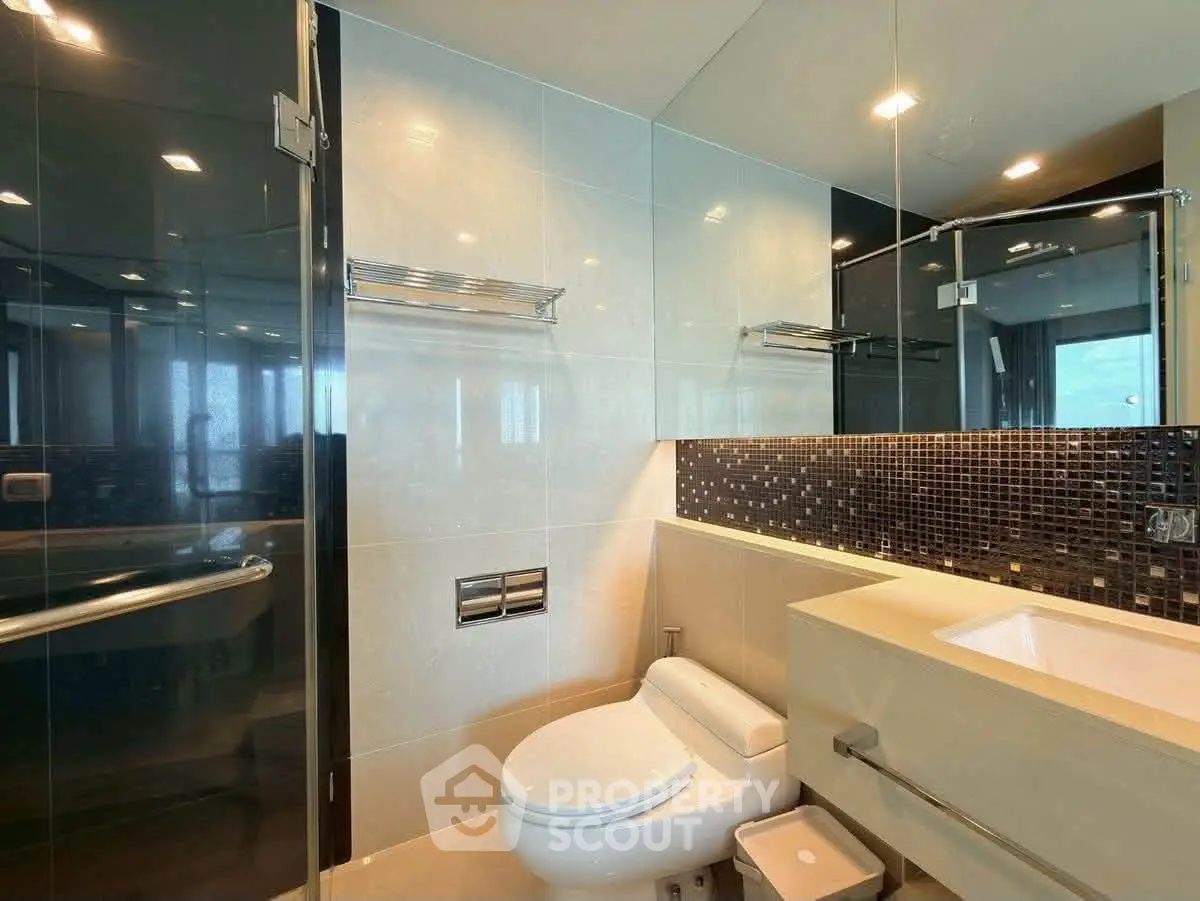 Modern bathroom with sleek design, featuring glass shower and stylish tile accents.