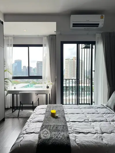 Modern bedroom with city view, featuring a cozy bed and a study desk by the window.