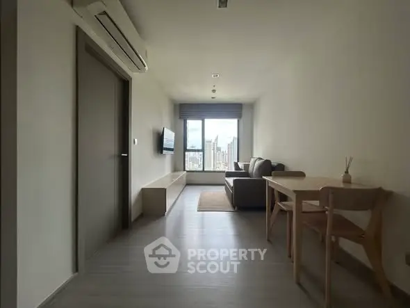 Modern living room with city view, featuring sleek furniture and natural light.