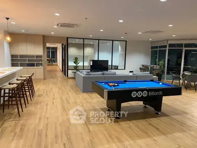 Spacious modern living room with billiards table and open kitchen, perfect for entertainment and relaxation.