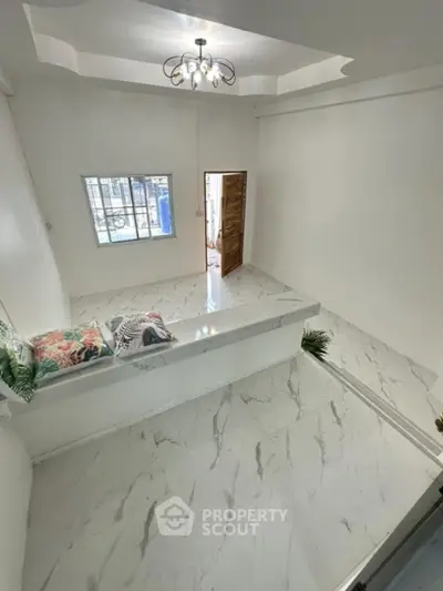 Spacious modern living room with elegant marble flooring and stylish lighting.