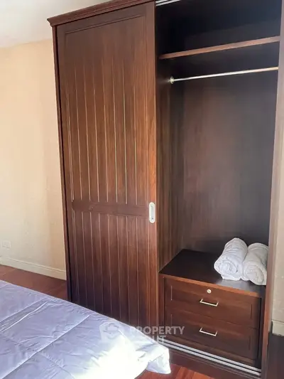 Spacious bedroom with elegant wooden wardrobe and cozy bedding