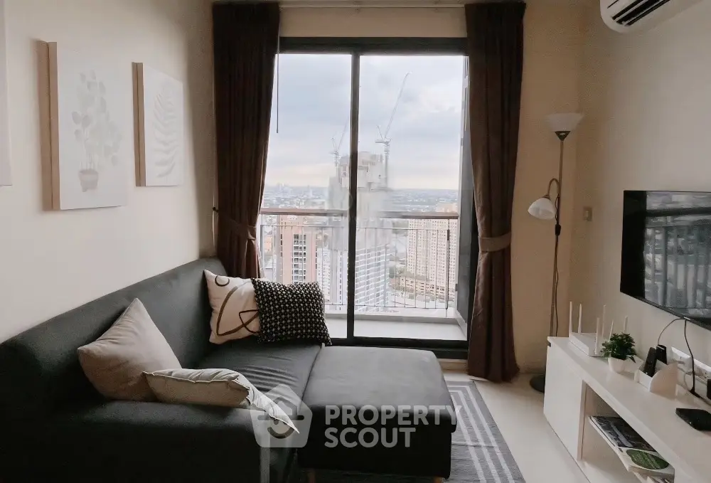 Stylish living room with city view, cozy sofa, and modern decor in high-rise apartment.