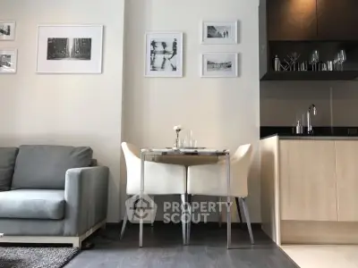 Modern living room with cozy dining area and sleek kitchen design.