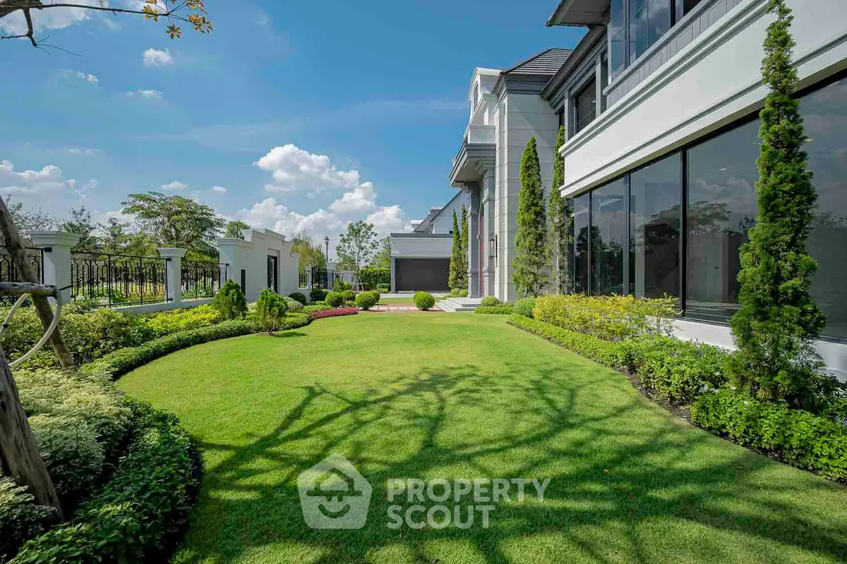 Luxurious garden view of modern estate with manicured lawn and elegant architecture.