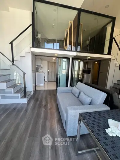 Modern duplex apartment with sleek design and open layout, featuring a stylish staircase and spacious living area.