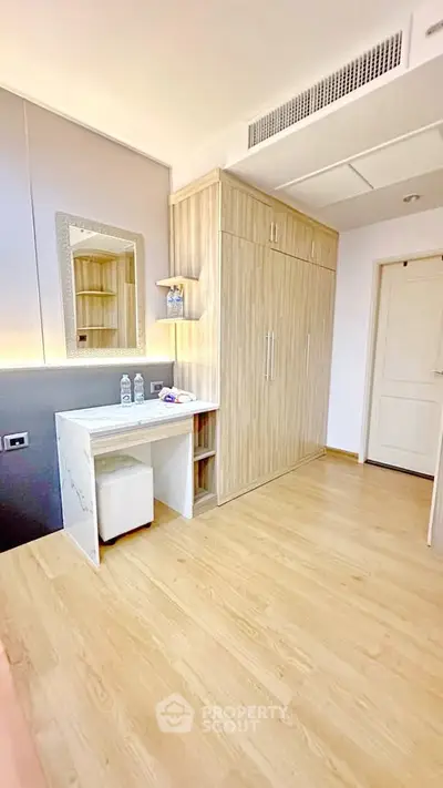 Modern bedroom with built-in wardrobe and vanity in a stylish apartment