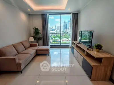 Modern living room with city view, featuring sleek furniture and large windows for natural light.
