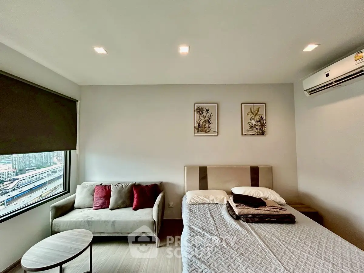 Modern bedroom with city view, featuring cozy bed and stylish decor in a high-rise apartment.