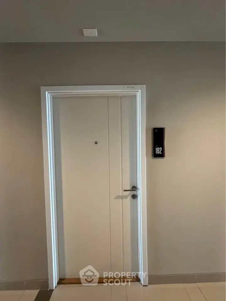 Modern apartment entrance with sleek door and room number 162