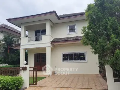 Charming two-story house with lush greenery and spacious entrance