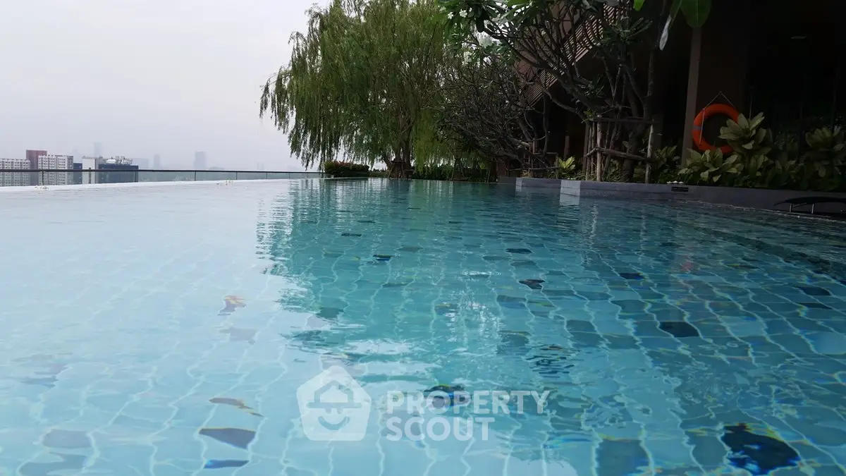 Luxurious rooftop infinity pool with stunning city views and lush greenery, perfect for relaxation and leisure.