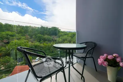 Charming balcony with stunning forest view, featuring cozy seating and elegant decor, perfect for relaxation.