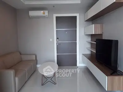 Modern living room with sleek furniture and wall-mounted TV unit.