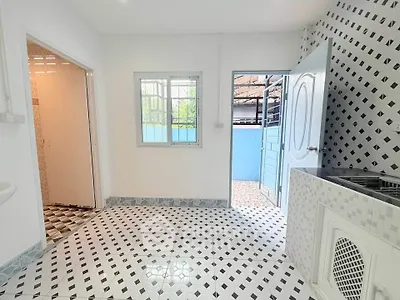 Bright kitchen with patterned tiles and open door to outdoor area