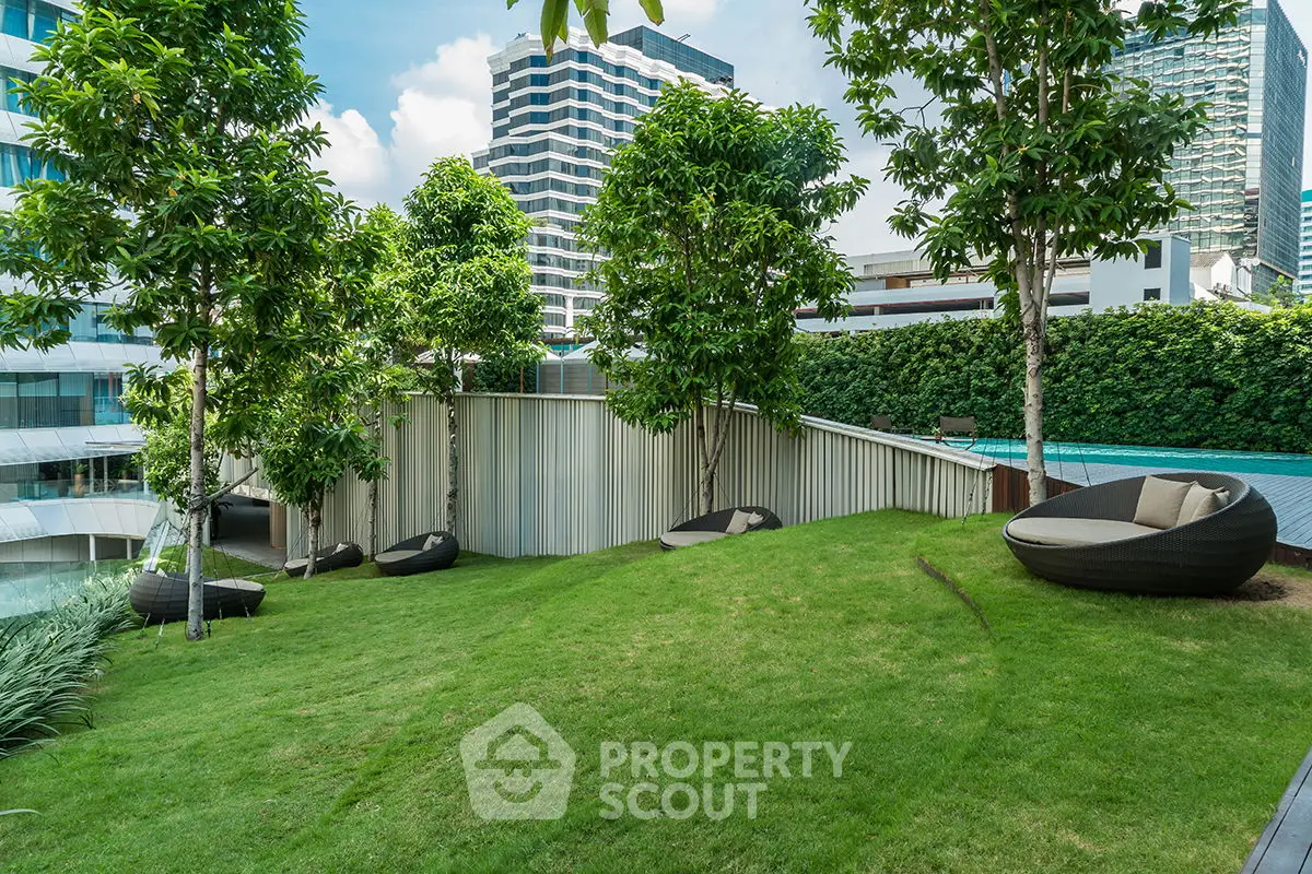 Luxurious garden area with modern seating and lush greenery in urban setting.