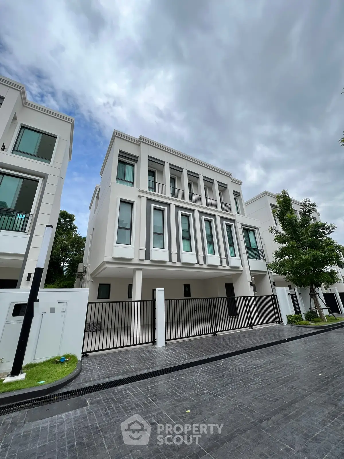 Elegant modern townhouse with sleek facade and spacious driveway in upscale neighborhood.