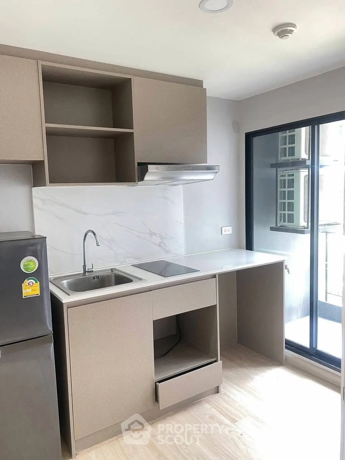 Modern kitchen with sleek cabinetry and balcony view in a stylish apartment