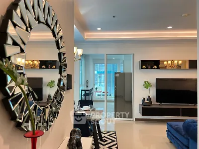 Modern living room with stylish decor and open layout, featuring a large mirror and sleek furniture.