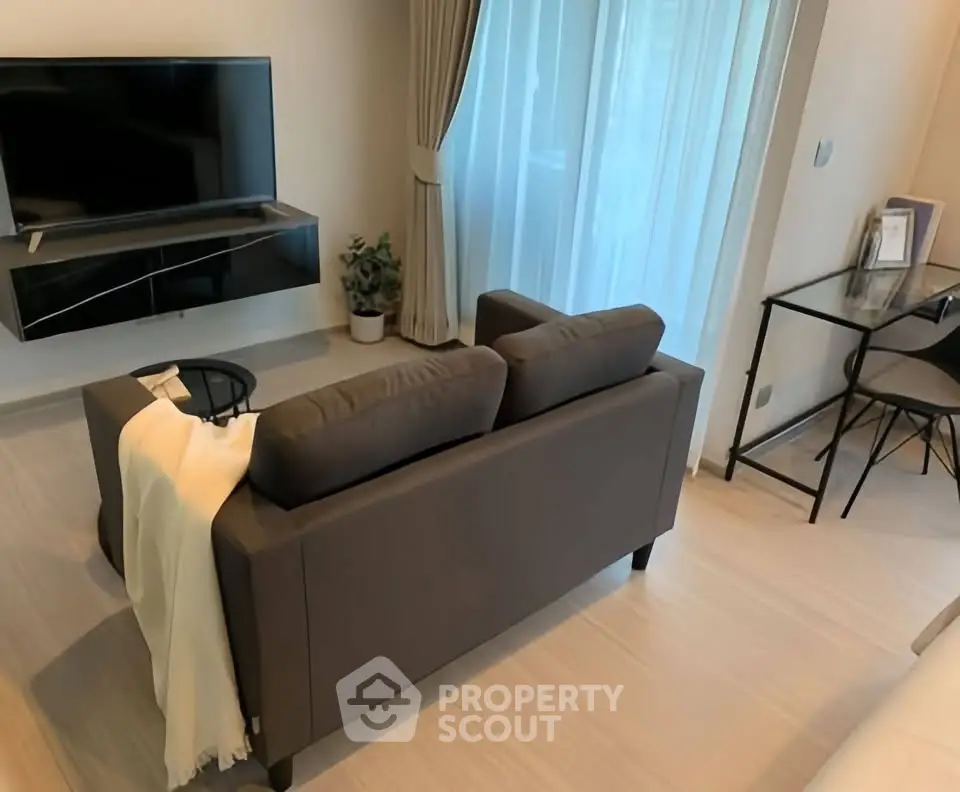 Modern living room with sleek sofa and wall-mounted TV, perfect for relaxation.